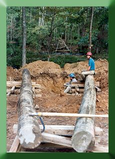 Laying out tower poles; opposite side tower completed in background
