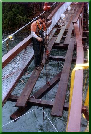 Keith Monohan installing floor beam, note bent and cut top chords behind him.