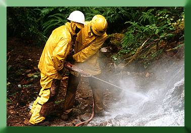 Russ Dalton and Jeremy Eyre double team the rock drill to drill a 5' deep blast hole.