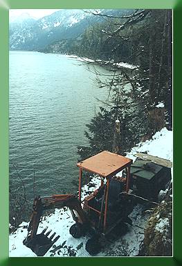 Kubota with compressor above lake on new trail.