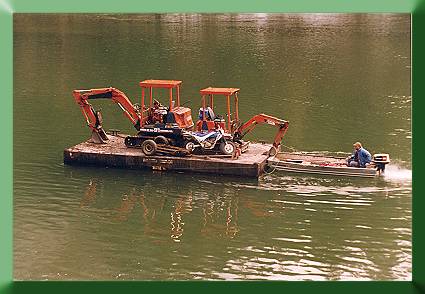 Robert Mitton pushing the barge to Noisy Creek with skiff.
