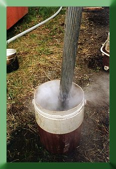 Dipping 2" bridge strand into acid for cleaning, prior to socketing.