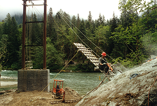 Drilling 14' deep rock anchors from suspended ramp.