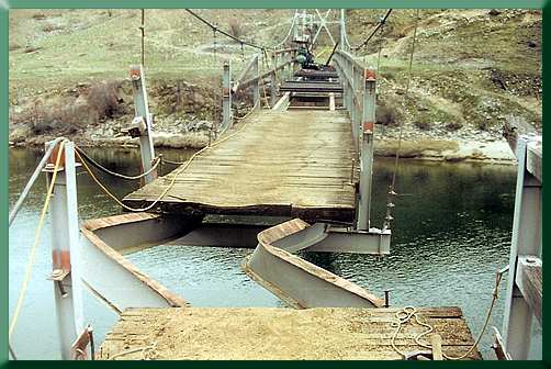 Buckled stringers after deck removal; new decking going down in the distance.
