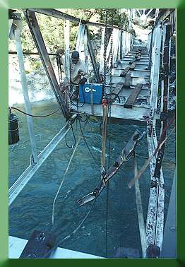 Cutting free bent truss sections:  old chord  member hanging from skyline.