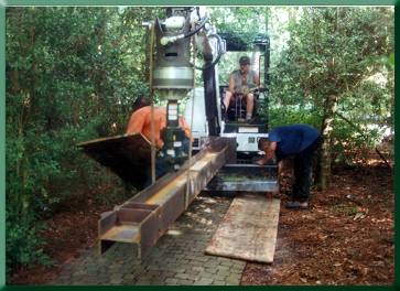 Transporting tower leg--using plywood sheets under excavator for traveling over brick paths and garden areas.