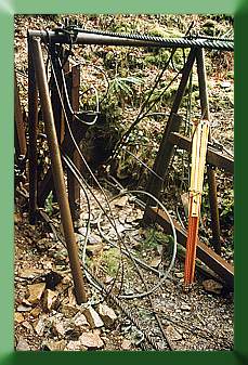 The original tower; note mainlines on ground, handrail cables atop tower.  The yellow and orange item is a transit tripod.